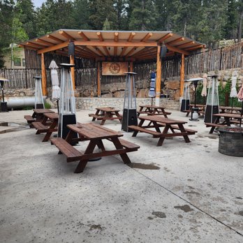 Outdoor patio with picnic tables, propane heaters, and a covered pavilion