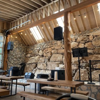 Stone-wall interior space with a timber roof &mdash; the live-music room