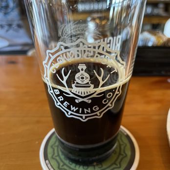 Pint of dark beer in a Cloudcroft Brewing Co. logo glass