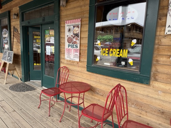 Burro Street Bakery — green-trim boardwalk storefront with the 'Famous Mountain Top PIES' poster, painted ICE CREAM window, and red bistro chairs out front