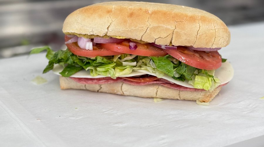 Italian-style sub with salami, provolone, lettuce, tomato, and red onion on a ciabatta roll