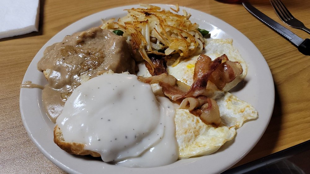 Chicken-fried steak with biscuit and gravy, bacon, fried eggs, and hash browns