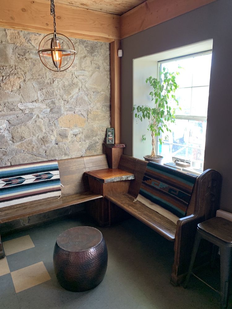 Interior seating nook with stone wall, serape blankets, and pendant light