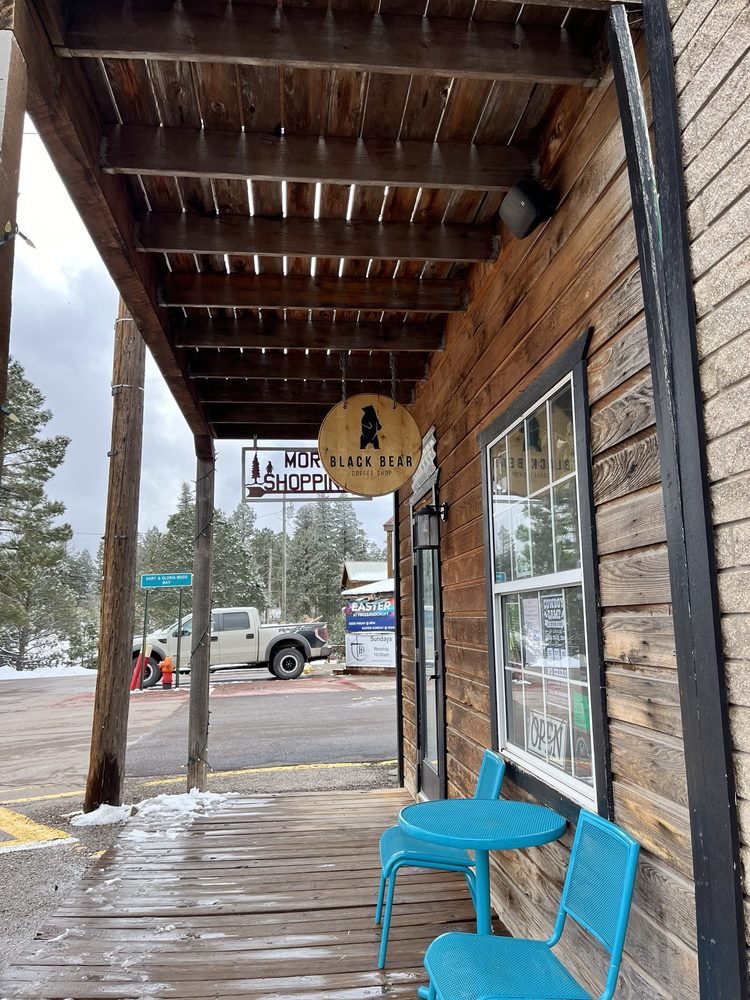 Covered front porch with turquoise chairs at Black Bear Coffee