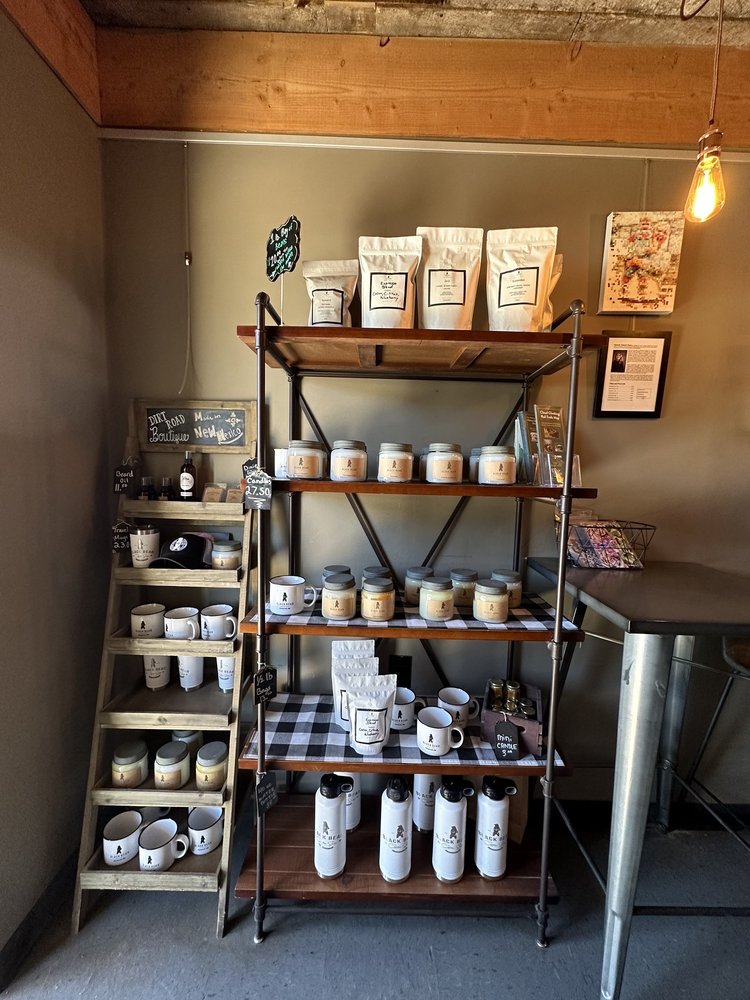 Merchandise shelf with mugs, roasted beans, and tumblers for sale