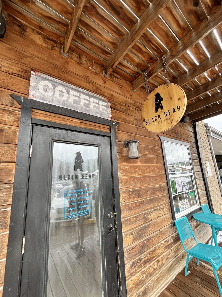 Front entrance with COFFEE lettering and round wood logo sign