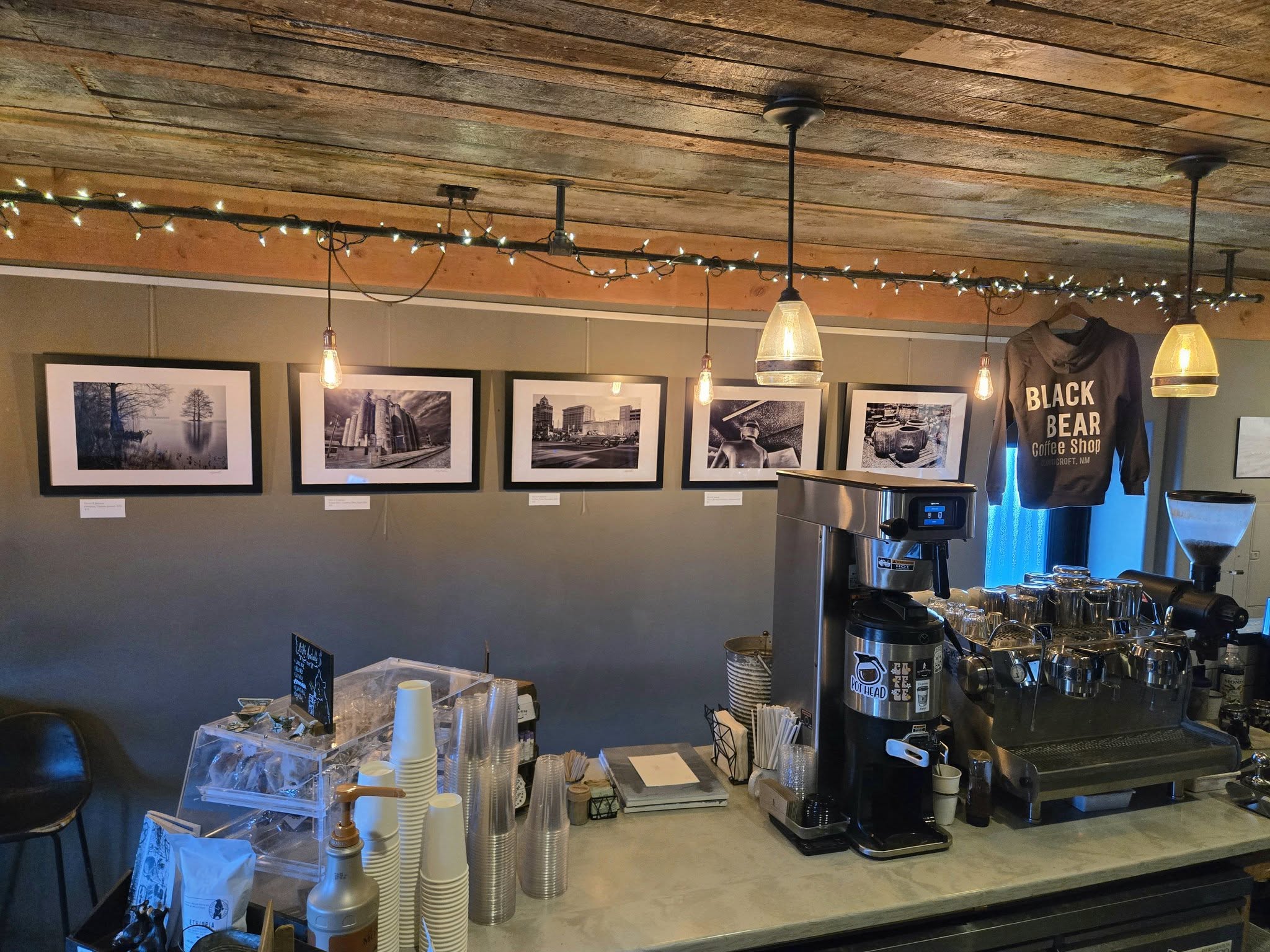 Gallery wall with framed black-and-white photography above the espresso bar