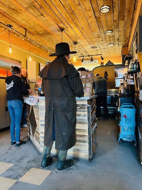 Customer in a western duster ordering at the Black Bear counter