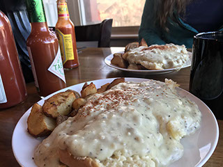 Biscuits and gravy with breakfast sides at the cafe