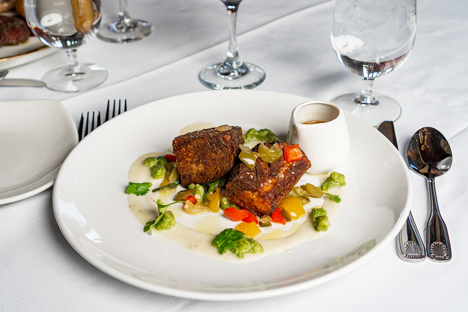 Seared short rib with seasonal vegetables on cream sauce at Eighteen99