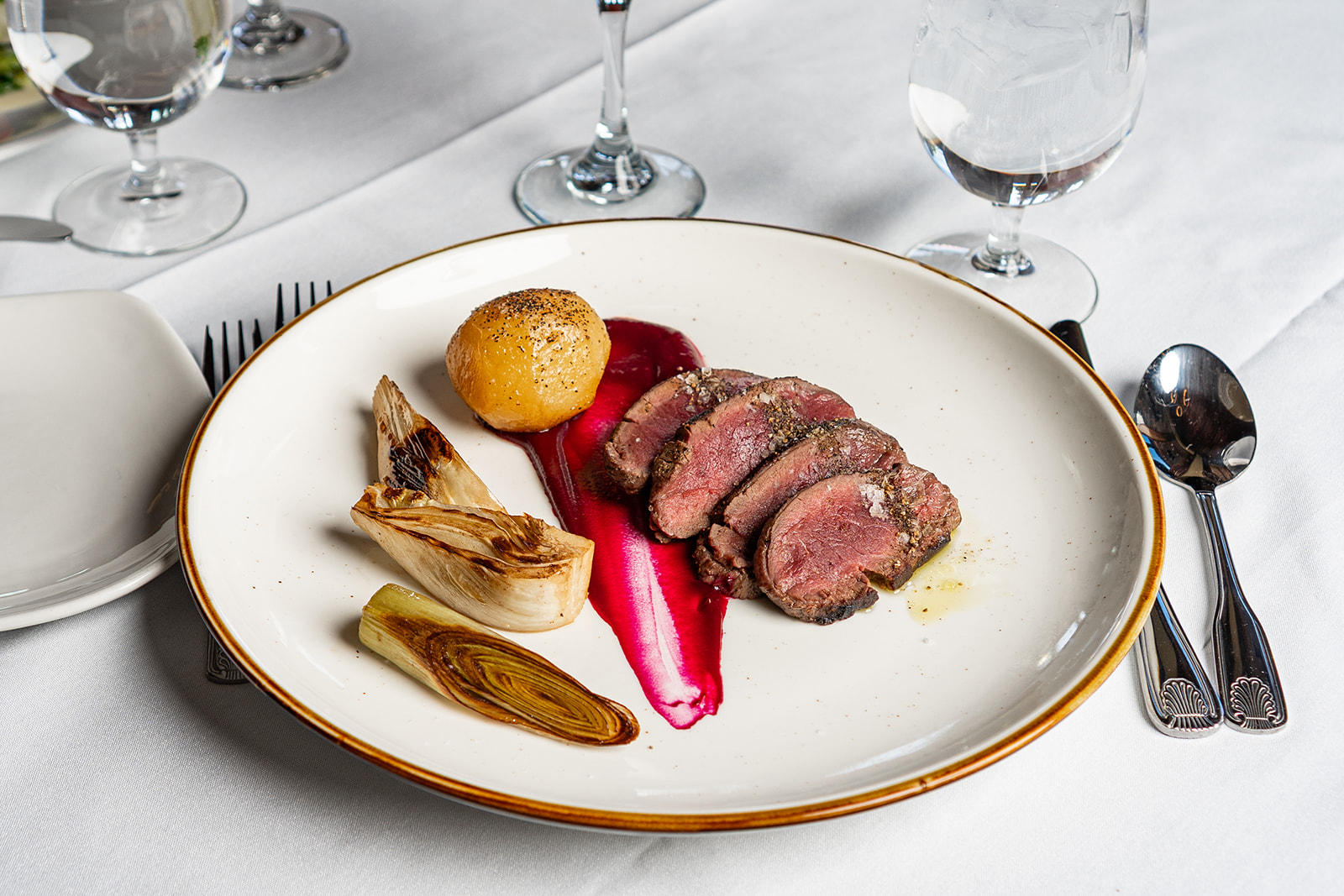 Sliced duck breast with artichoke, beetroot purée, and roasted potato at Eighteen99