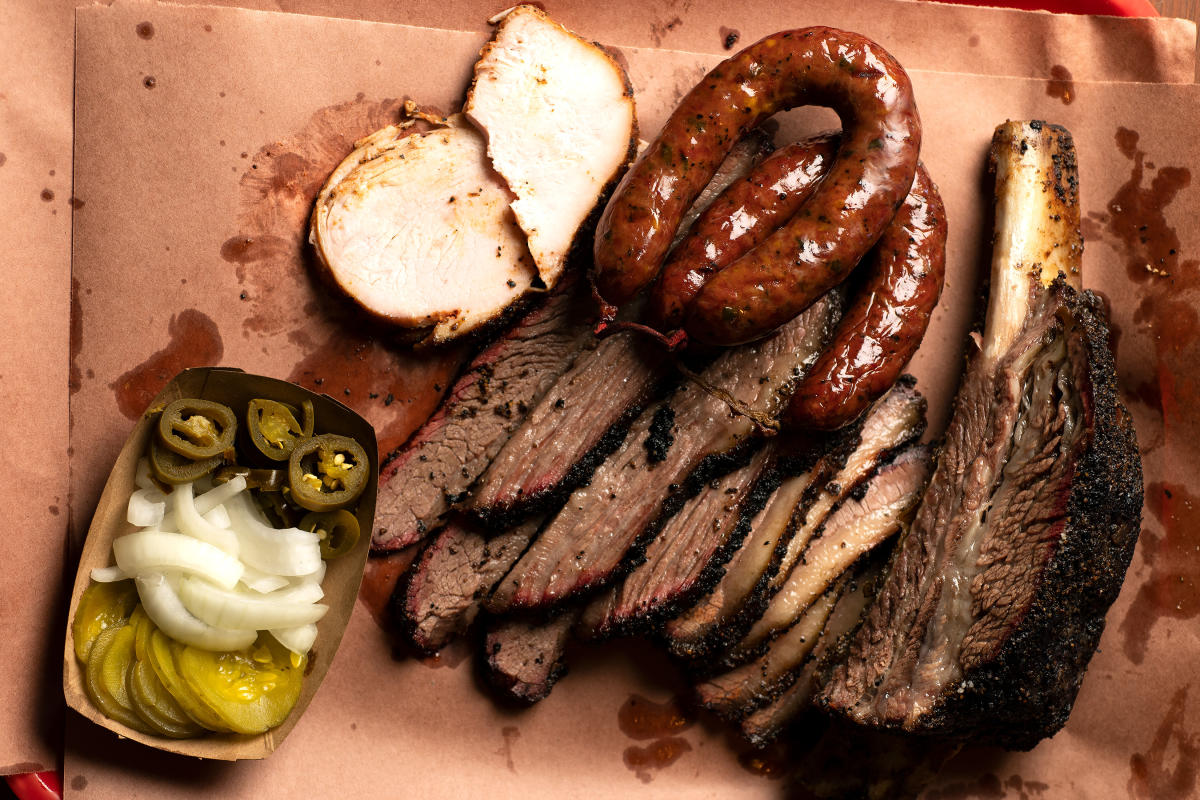 Brisket, sausage, turkey, and sides on butcher paper at Mad Jack's BBQ