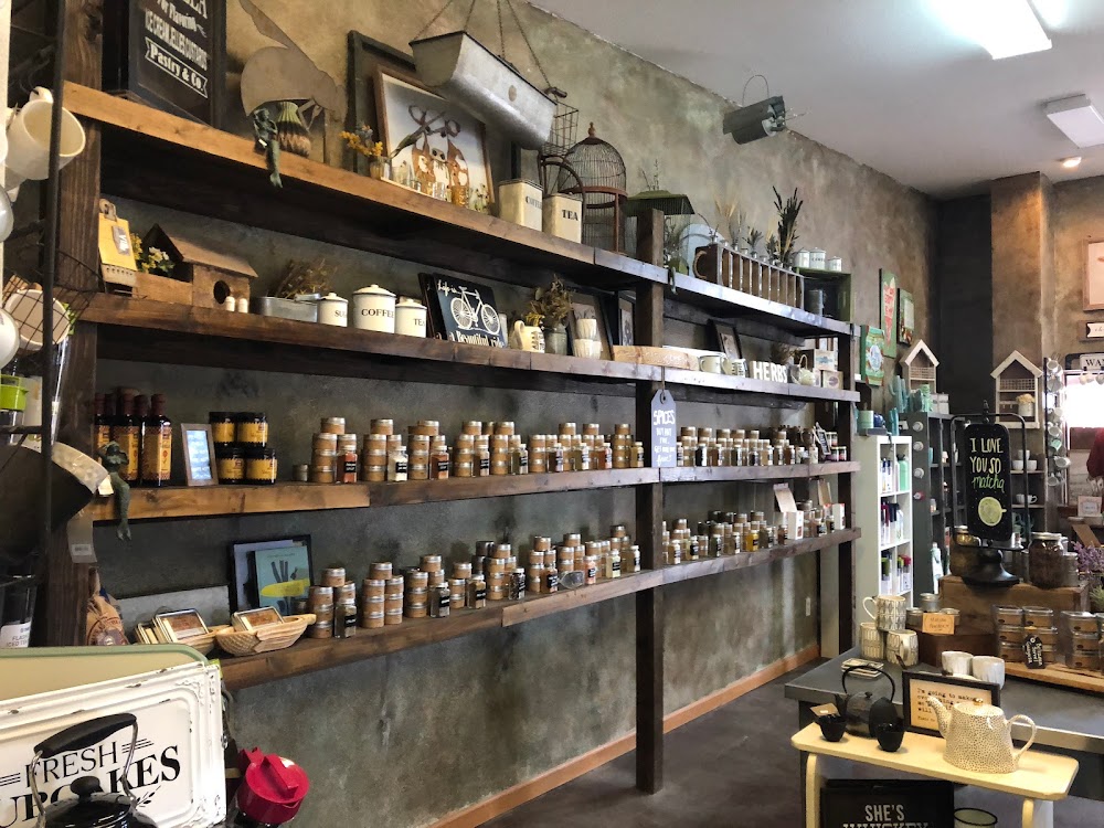 Wall of loose-leaf tea tins on rustic shelves at Old Barrel Tea Company