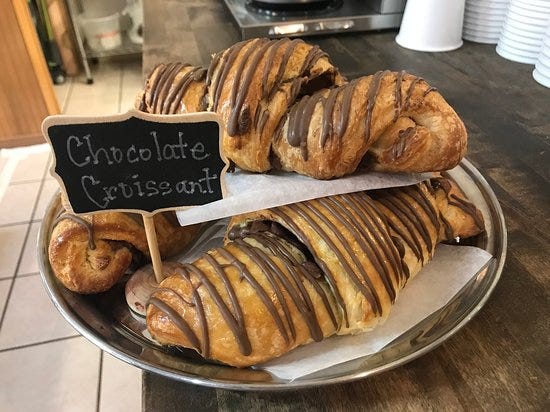 Chocolate croissants drizzled with chocolate on a plate at KennaBelles