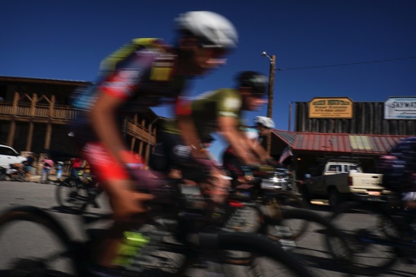 Motion-blurred racers speeding past a Cloudcroft storefront
