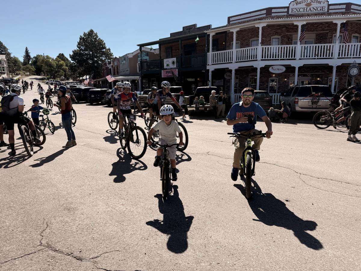Kids event: young rider in the lead with a parent riding alongside on Burro Avenue