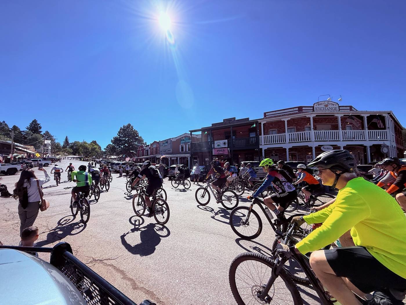The field rolling out on Burro Avenue past the Burro Street Exchange at the start of the High Altitude Classic, under a clear blue sky