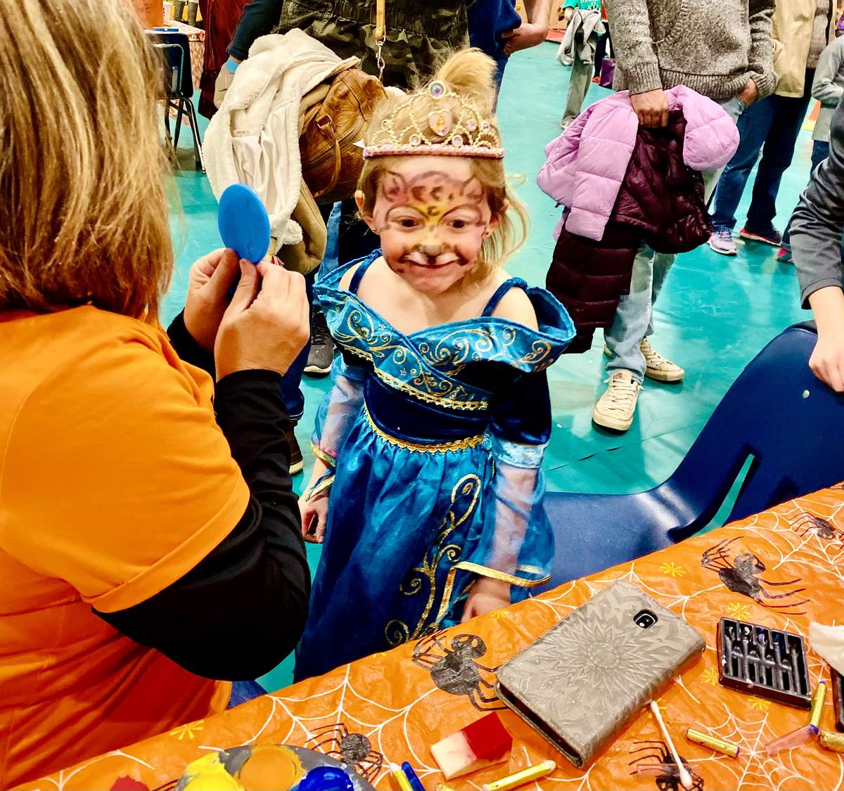 A child in a princess costume getting face paint at the Cloudcroft Schools Fall Festival