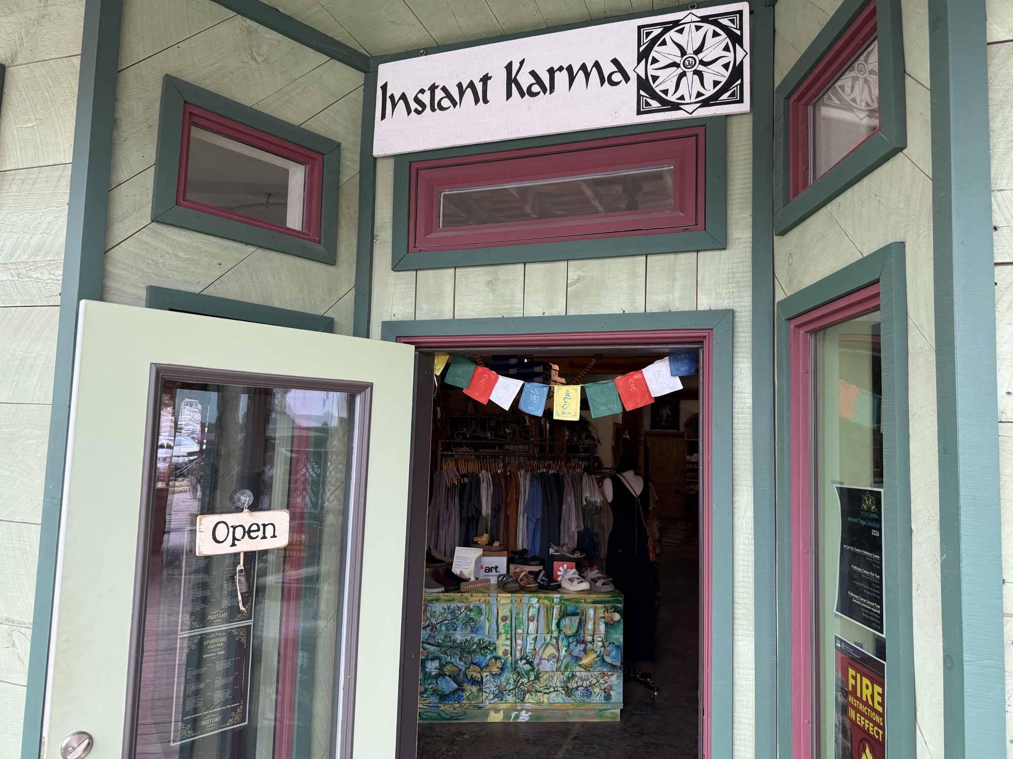 Instant Karma — open doorway with prayer flags above the entrance