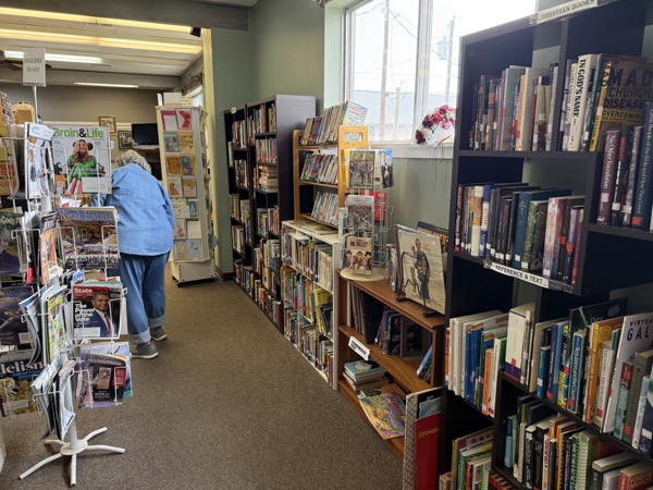 Book and magazine room at King's Treasure with rotating magazine rack and bookshelves of used books
