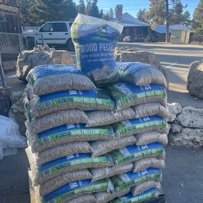 Pallet of Cloud Mountain wood pellet fuel bags stacked outside New Village Hardware on a sunny day