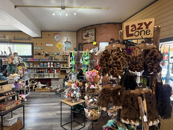Plush and gag-gift section at Poke The Bear with leopard-print Lazy One animal hats, plush toys, and Cloudcroft signs