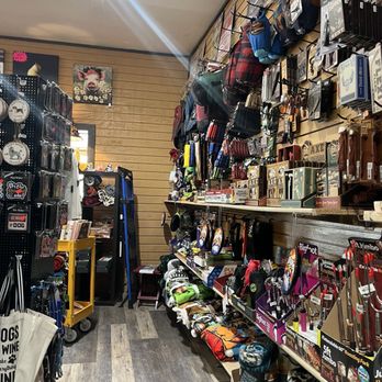 Wall display at Poke The Bear packed with bags, accessories, outdoor gear, and signs