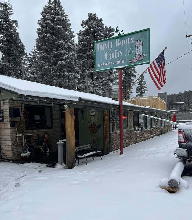 Dusty Boots Cafe storefront and Dusty Boots Motel sign in heavy snowfall