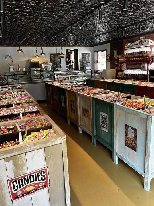 On-site candy and ice-cream shop with bulk candy bins along a pressed-tin ceiling