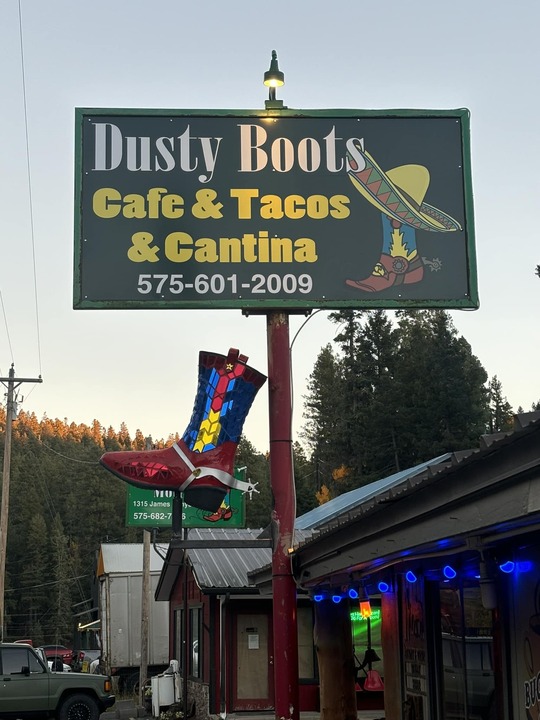 Dusty Boots Cafe and Cantina sign with painted boot at dusk