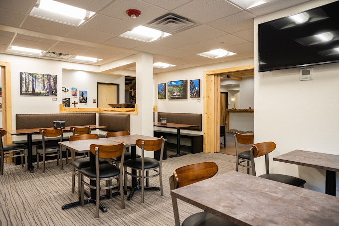 Breakfast dining room with booth seating, tables, and local art on the walls