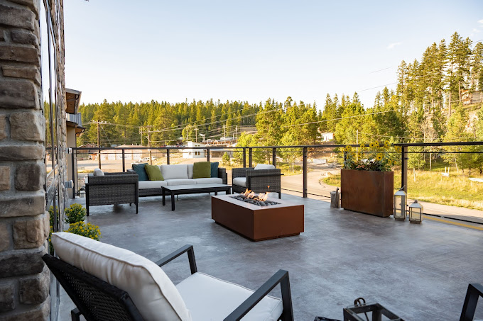 Aspen Deck with modern outdoor furniture, fire pit, and pine forest views