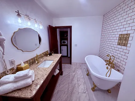 Clawfoot soaking tub with brass fixtures in the Anniversary Suite bath