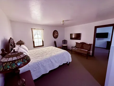 Guest room with Tiffany-style lamp and antique furnishings