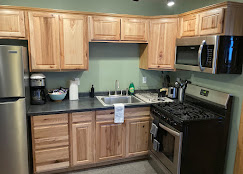 Hickory kitchen close-up at Osha Trail Lodging with stainless refrigerator, gas range, microwave, and Keurig coffee maker