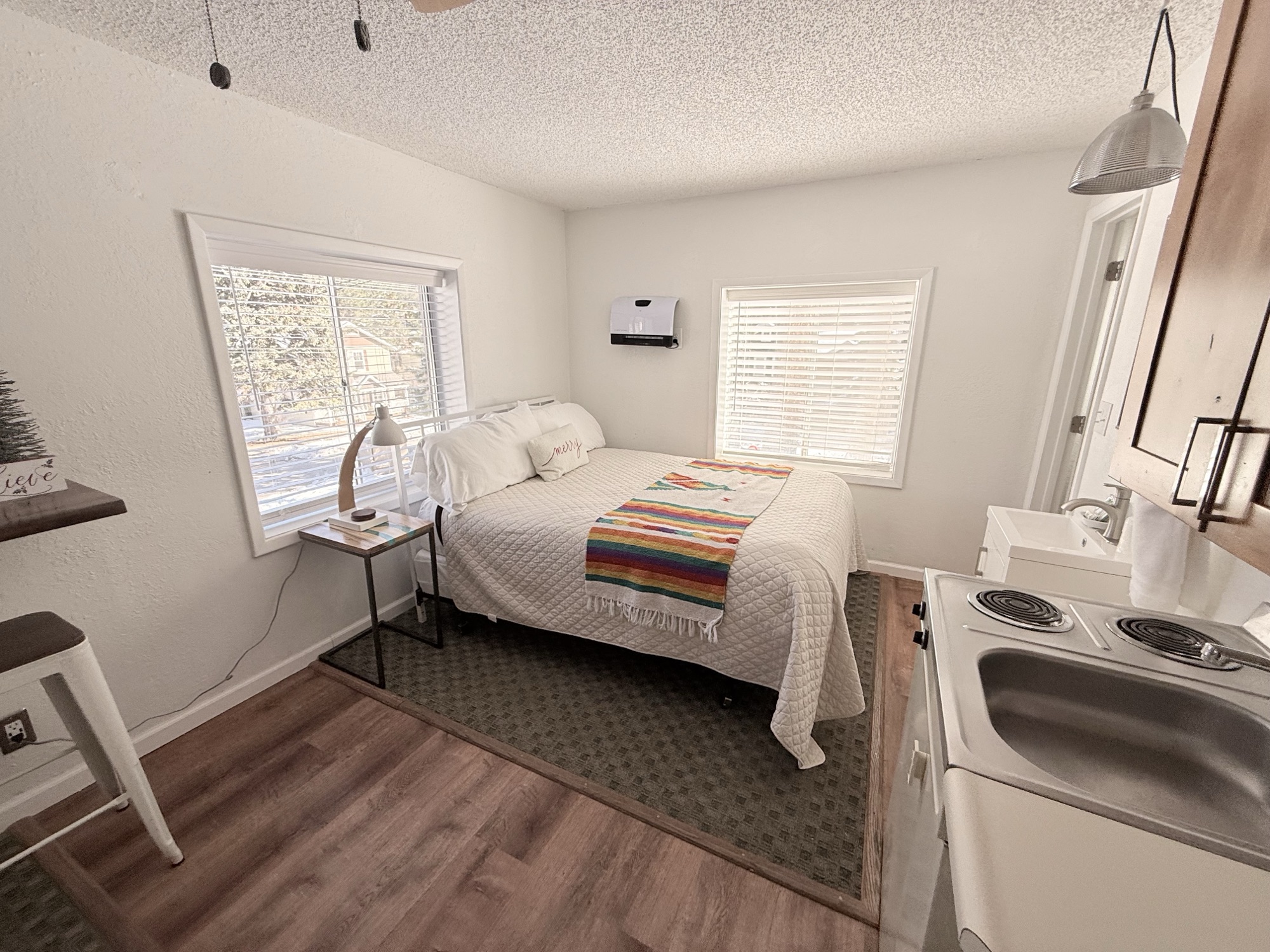 Queen room at The Summit Inn with serape blanket, mountain art, flat-screen TV, and kitchenette in view